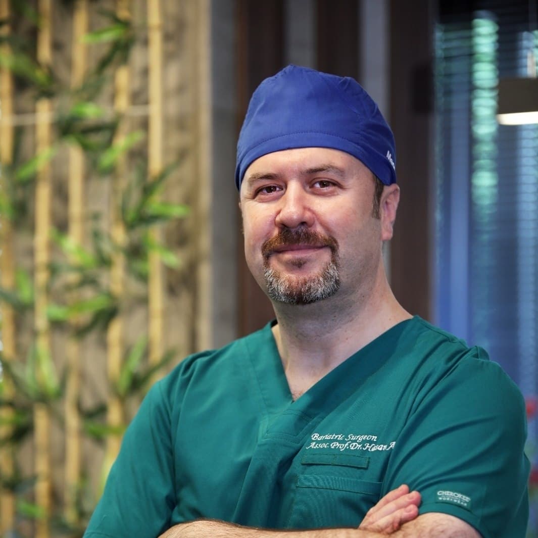 Assoc. Prof. Dr. Hasan Abuoğlu in surgical scrubs — 25+ years of bariatric surgery experience